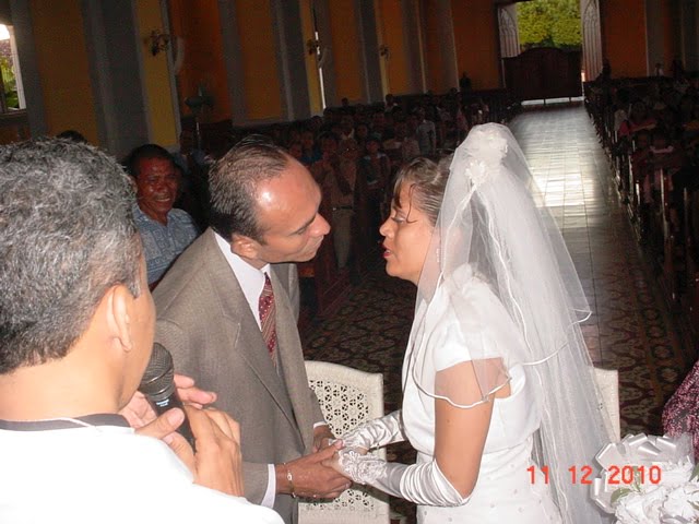 9.- El momento culminante del martrimonio efetuado por los oficios del padre Mario Vega. El novio besa a la novia